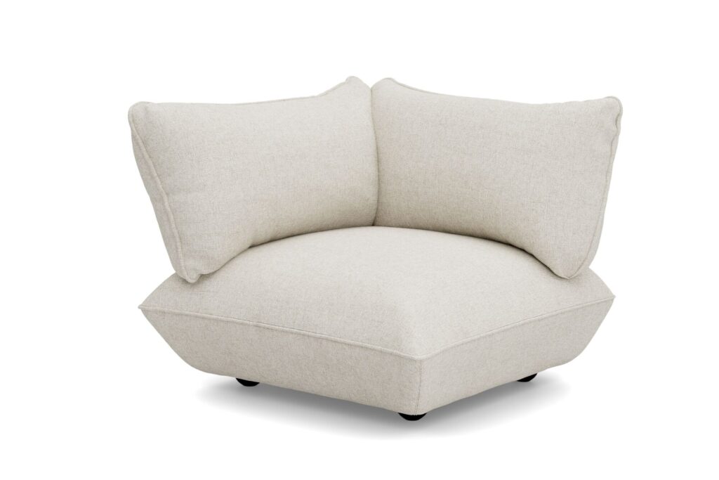 Le siège d'angle moderne Sumo en tissu bouclé beige clair est doté de coussins moelleux et d'une assise basse et large reposant sur de petits pieds noirs, le tout sur fond blanc.