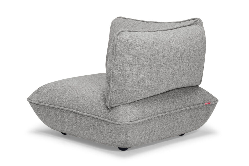 Le siège d'angle Sumo est un fauteuil moderne sans accoudoir en tissu gris clair, avec une assise épaisse et un dossier rembourré légèrement incliné.