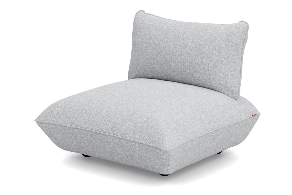 Un fauteuil moderne sans accoudoir avec un revêtement en tissu bouclé gris clair, une large assise coussinée et un dossier incliné, le tout sur fond blanc. Ce siège Sumo ajoute une texture confortable et du style à tout espace.