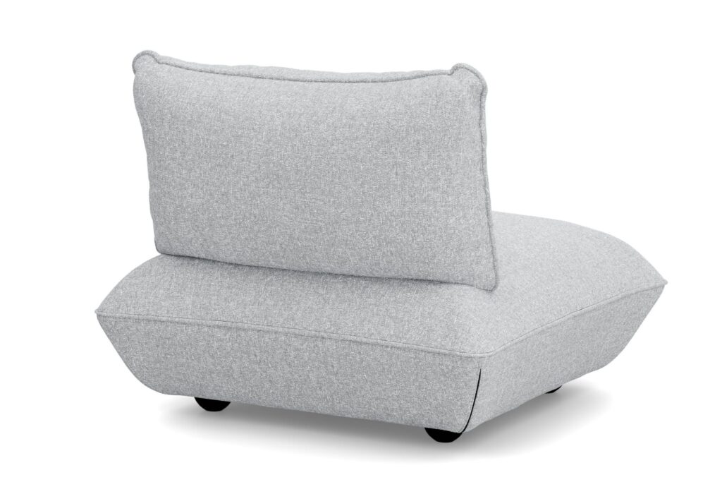 Chaise de salon moderne sans accoudoir avec une épaisse assise Sumo en tissu recyclé mélangé gris clair, un dossier incliné et des pieds bas noirs, vue de l'arrière côté gauche.