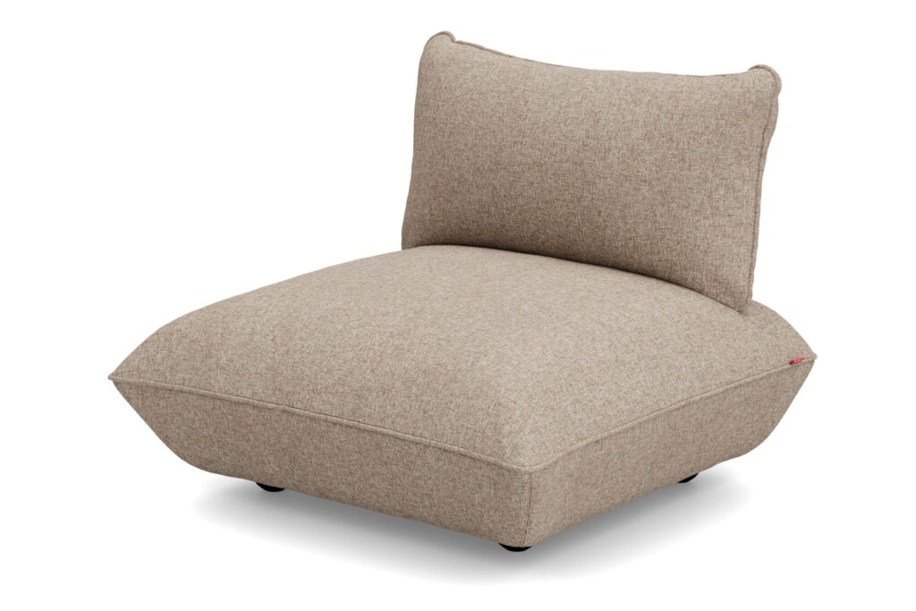 Chaise de salon moderne sans accoudoir avec une assise basse et large et un dossier légèrement incliné, revêtue d'un tissu bouclé beige clair recyclé.