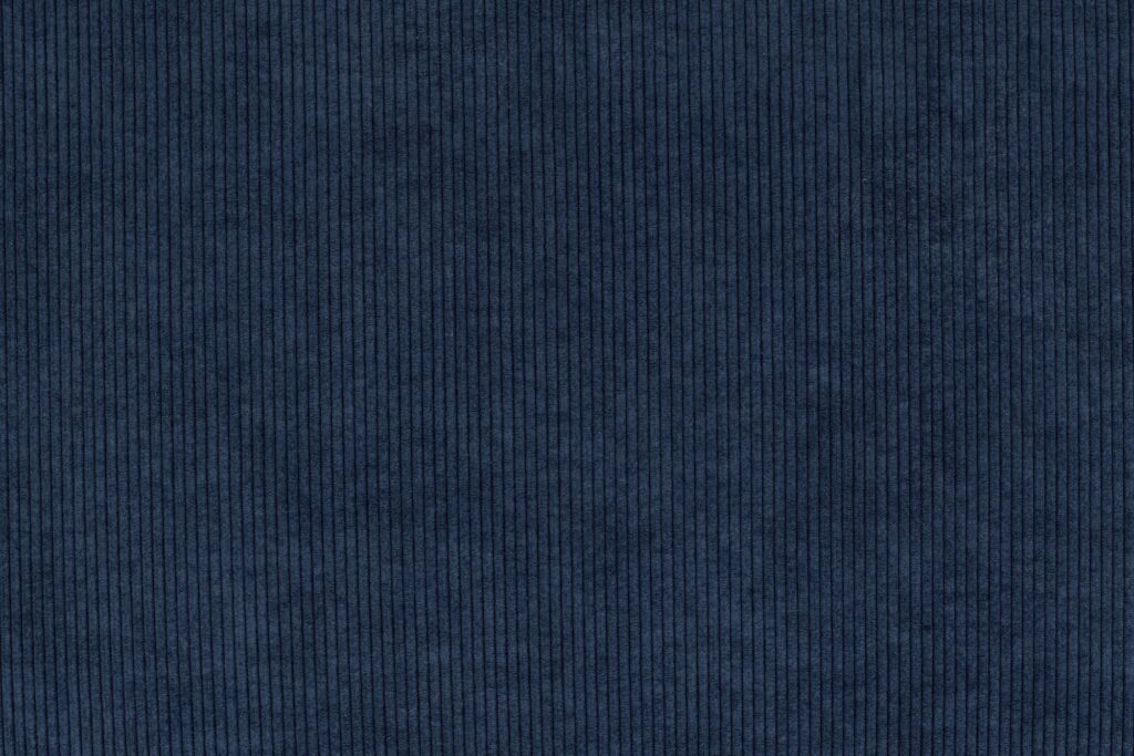 Tissu en velours côtelé bleu foncé avec de fines stries verticales, régulièrement espacées et d'une texture homogène sur toute la surface - idéal pour être associé au Sumo Hocker ou mélangé à des touches de rose tendre.