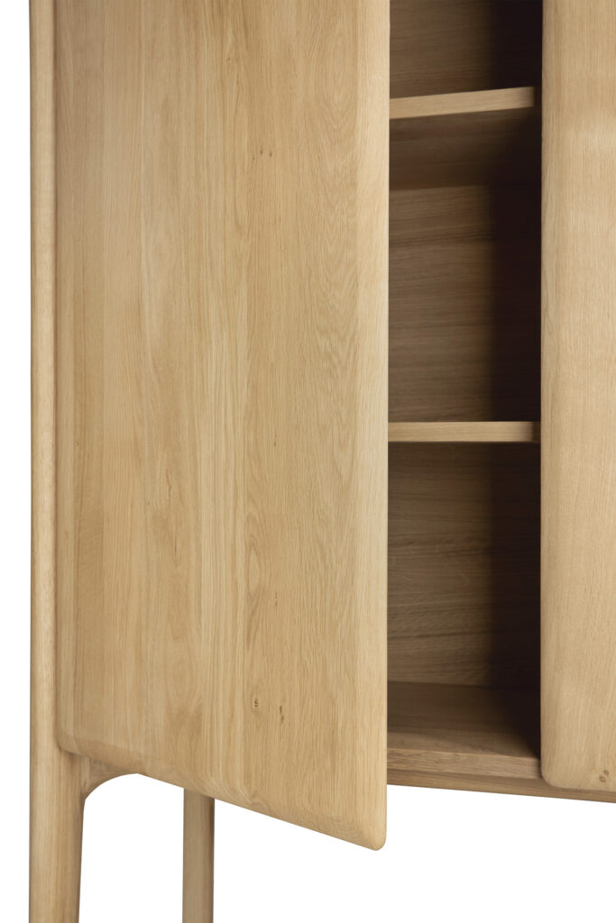 Armoire PI en bois clair avec une porte partiellement ouverte, révélant trois étagères intérieures. L'armoire présente une finition Chêne naturel lisse et un design minimaliste.