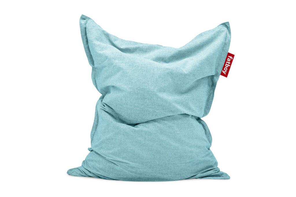 Un pouf Fatboy Original Outdoor bleu clair en Pacific Blue, doté d'une texture de tissu douce et d'une étiquette rouge sur le côté, présenté sur un fond blanc - parfait comme pouf d'extérieur.