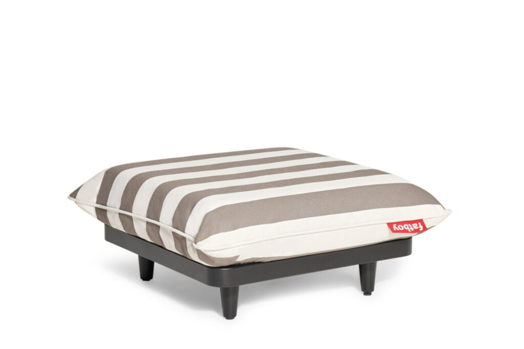 Pouf carré Paletti avec des pieds noirs et un coussin Stripe Cacao beige et blanc, avec une étiquette en tissu rouge sur un côté - un pouf élégant salon de jardin parfait pour tout espace extérieur.