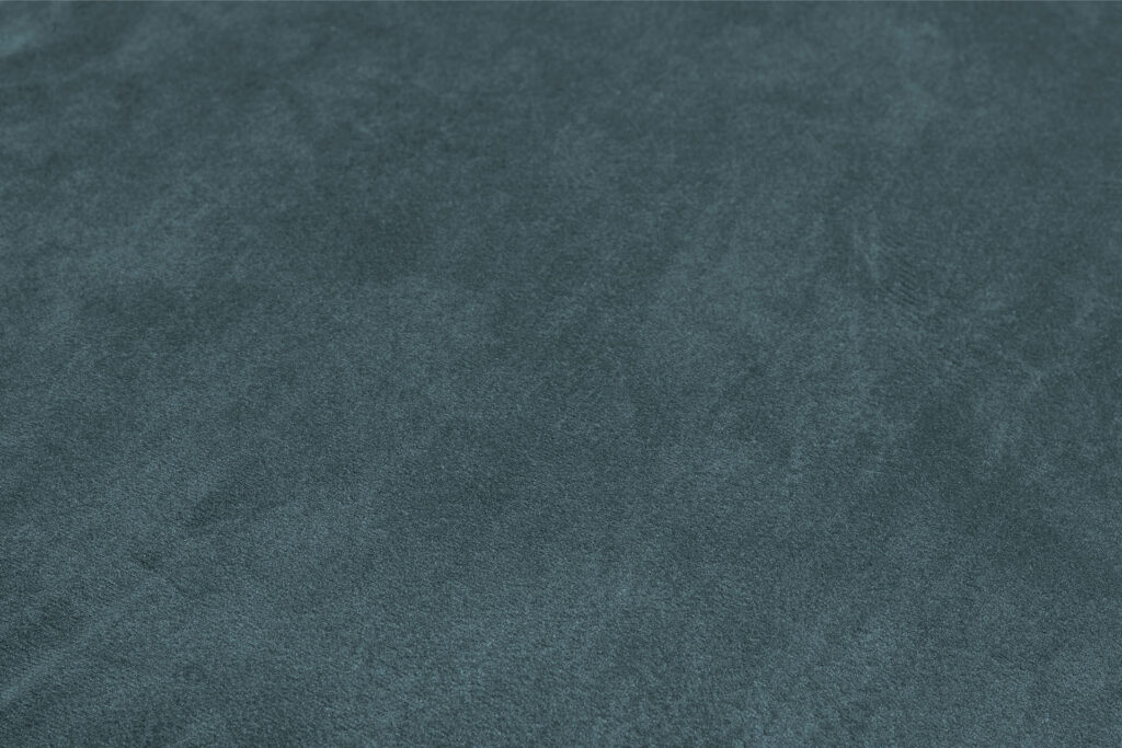Gros plan sur le tissu texturé bleu-vert lisse du Sumo - Loveseat, qui présente de subtiles variations d'ombres.