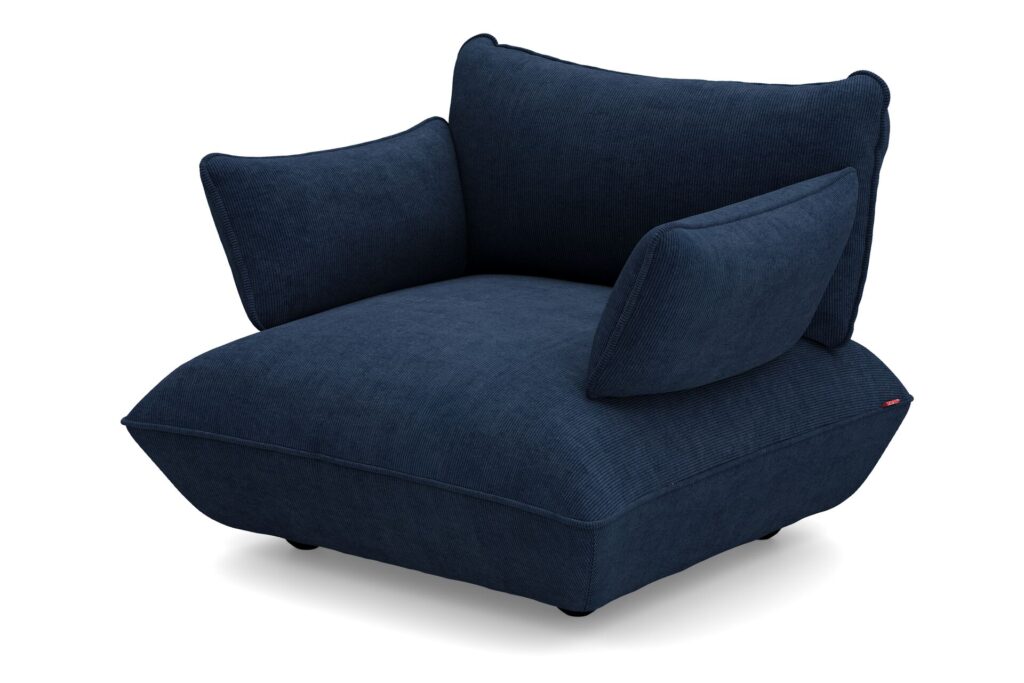 Le Sumo Loveseat est un fauteuil moderne, bleu marine profond, doté de coussins épais et rembourrés et d'une assise basse et large sur des pieds courts.