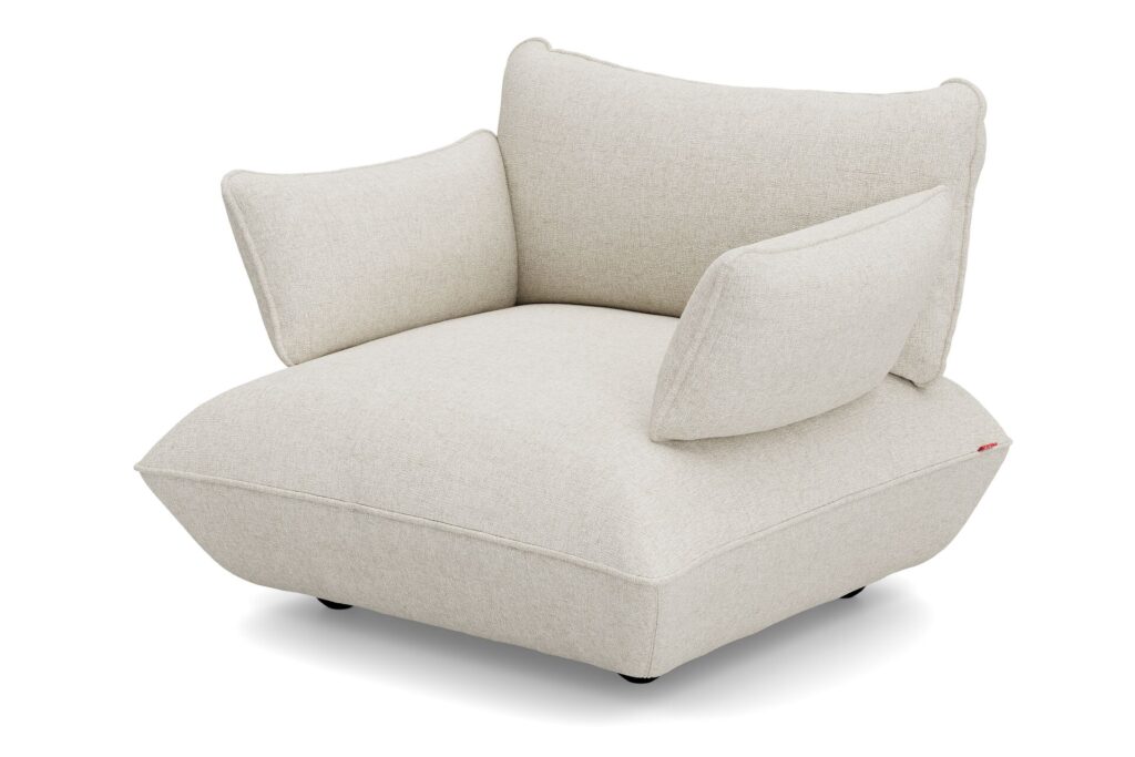 Le Sumo - Loveseat est un fauteuil moderne tapissé beige au design inspiré du Sumo, avec un dossier et des accoudoirs larges et angulaires, une assise épaisse et des pieds noirs courts. Il est idéal comme alternative compacte à une causeuse.