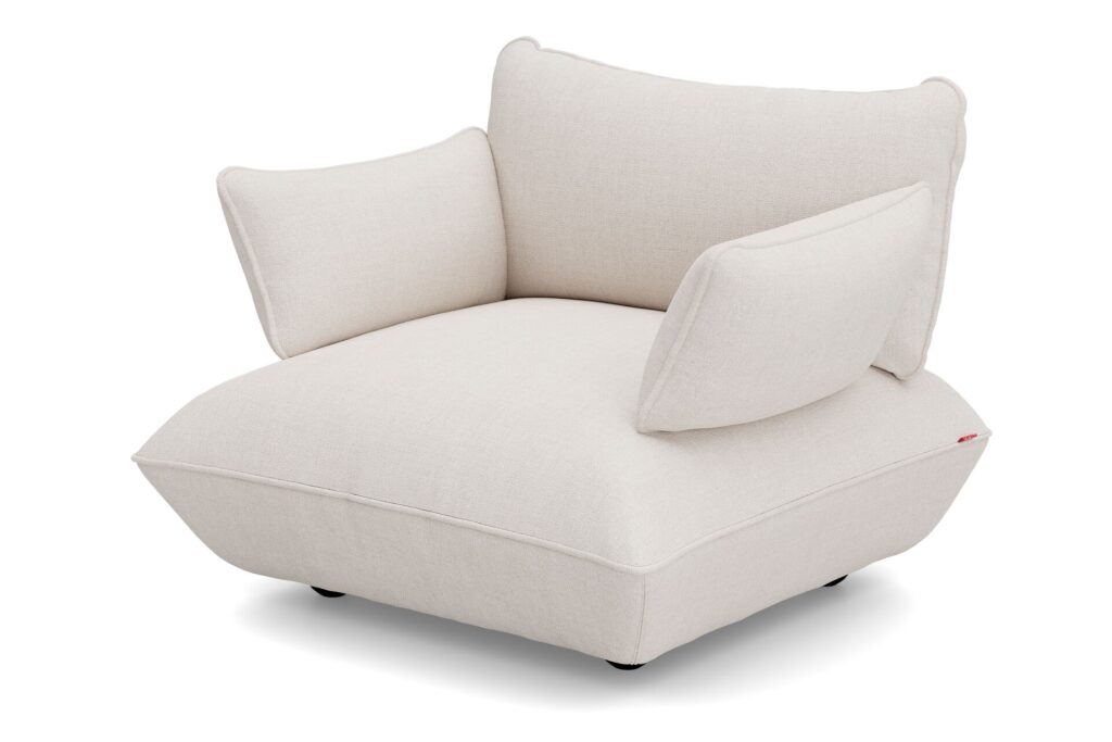 Un Sumo - Loveseat moderne et surdimensionné de couleur crème avec des coussins pelucheux et angulaires et des pieds noirs bas, sur un fond blanc.