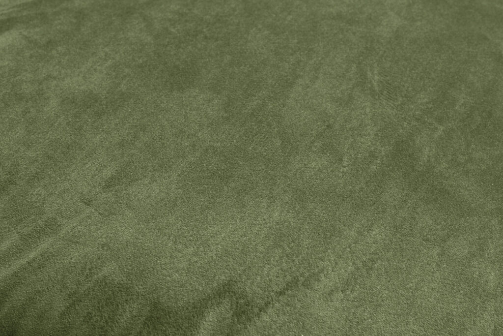 Gros plan sur Point Velvet Recycled - Petrol, montrant sa surface lisse de velours vert avec une texture subtile et des variations de lumière.