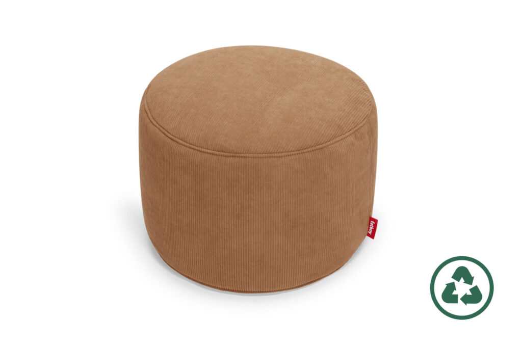 Un pouf Fatboy Point, rond et brun clair, avec une surface en tissu texturé et une petite étiquette rouge, à côté d'un symbole de recyclage.