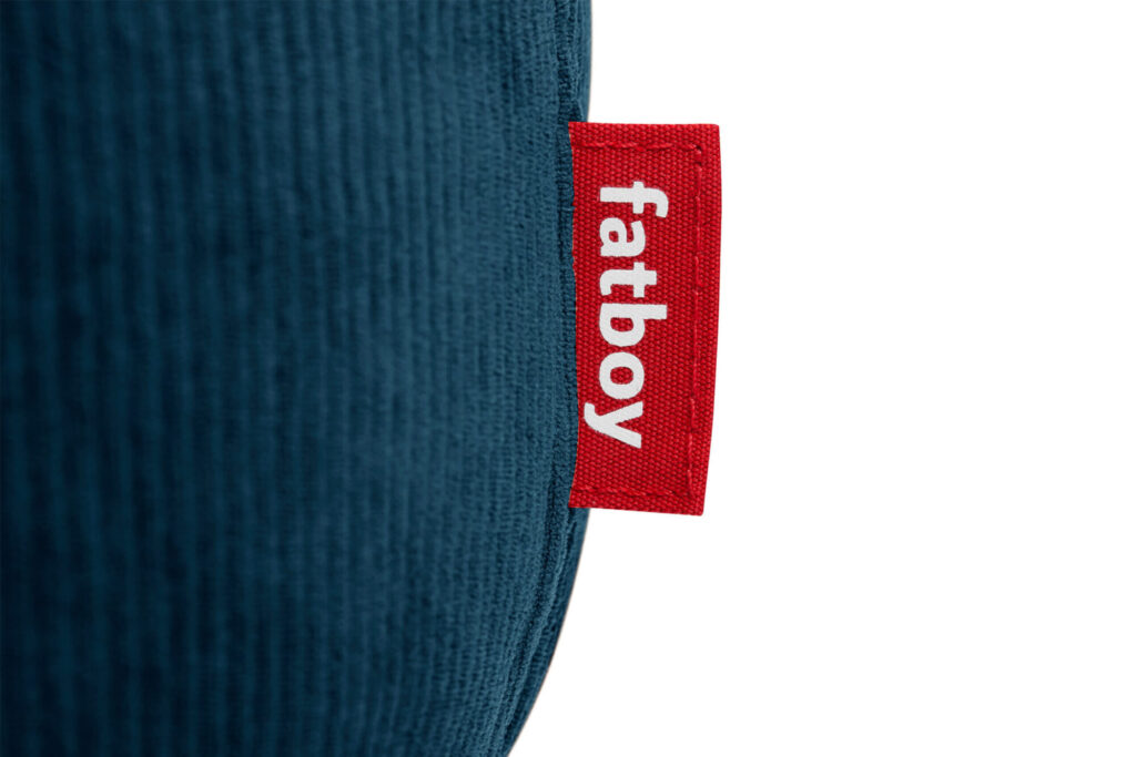Gros plan d'une étiquette rouge "fatboy" attachée à la surface texturée Cord Deep Blue du Fatboy Point Cord Deep Blue.