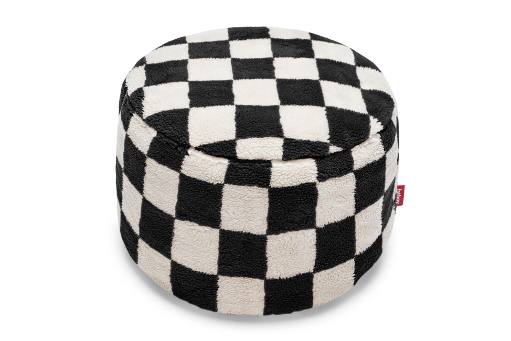 Un pouf ottoman rond avec un motif en damier noir et blanc et une texture douce et duveteuse Teddy Chess.