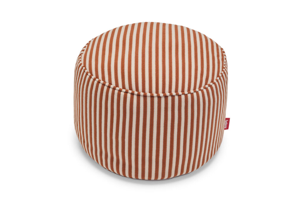 Pouf rond à rayures verticales marron et blanches, vu de dessus. Doté du style Fatboy Point en Cognac Creme, il comprend une petite étiquette en tissu rouge attachée sur le côté.