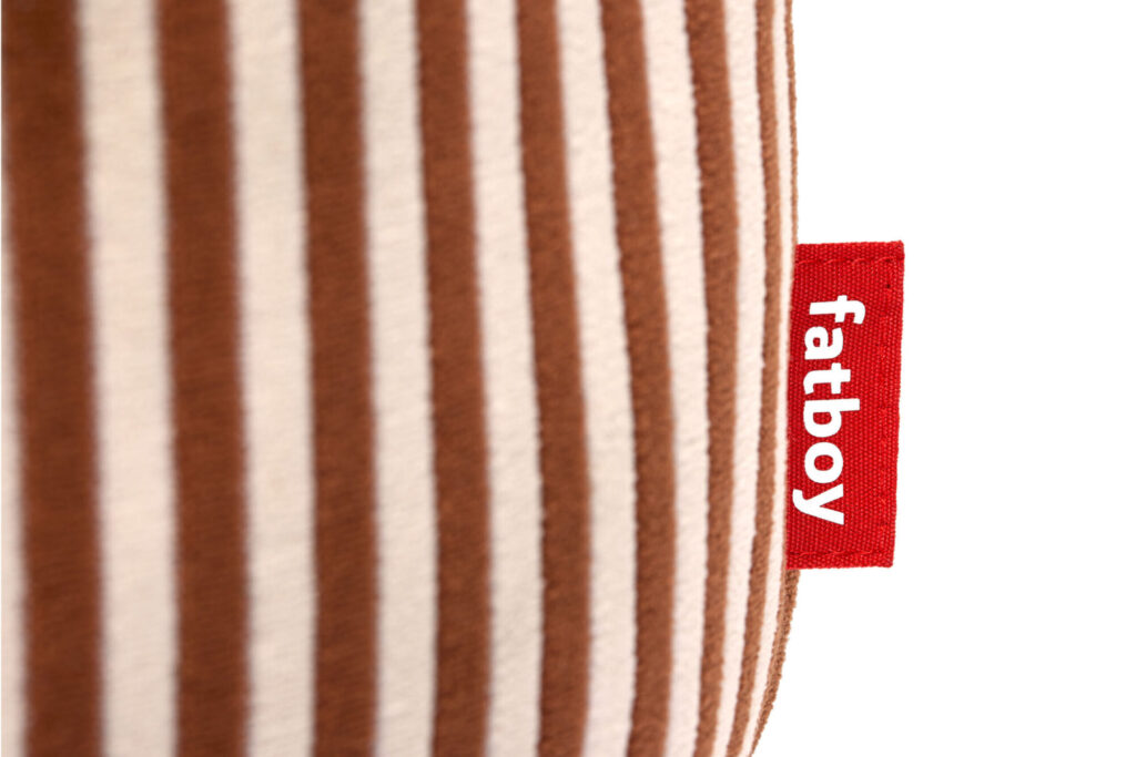 Gros plan sur le Fatboy Point Terry Cognac Creme, un tissu rayé marron et beige avec une étiquette rouge "fatboy" attachée à la couture.