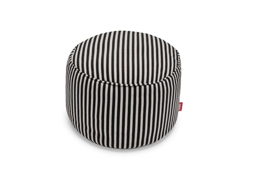 Un pouf Fatboy Point rond avec des rayures verticales noires et blanches et une petite étiquette en tissu rouge sur le côté, sur fond blanc.