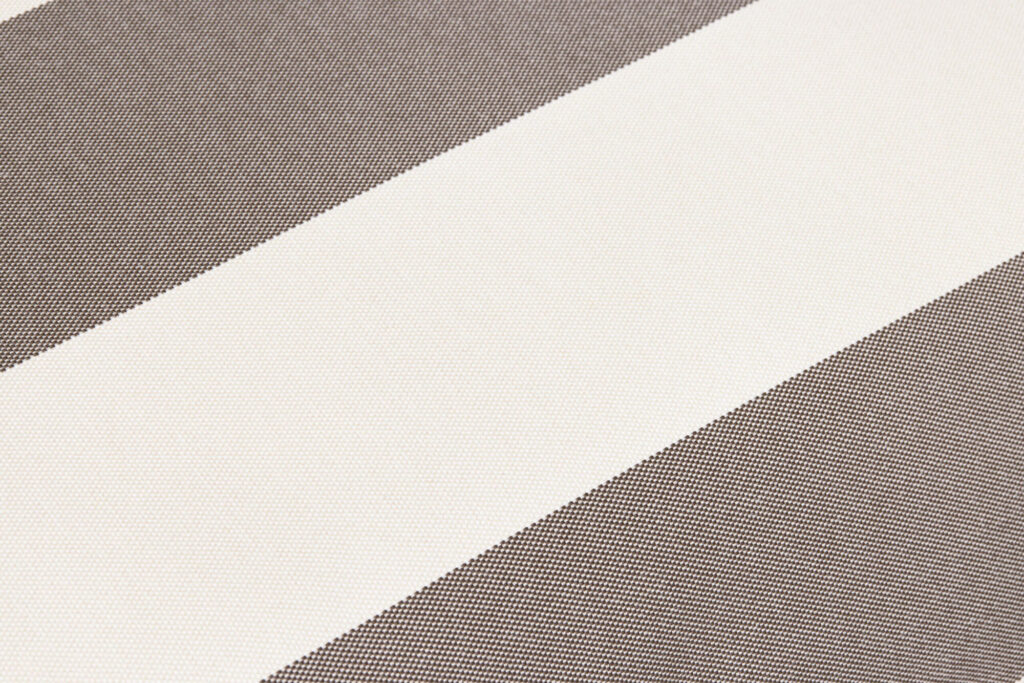 Gros plan d'une surface de tissu à rayures diagonales alternées en blanc et en marron, faisant partie du motif Stripe Cacao. La texture du tissu est clairement visible sur l'image.