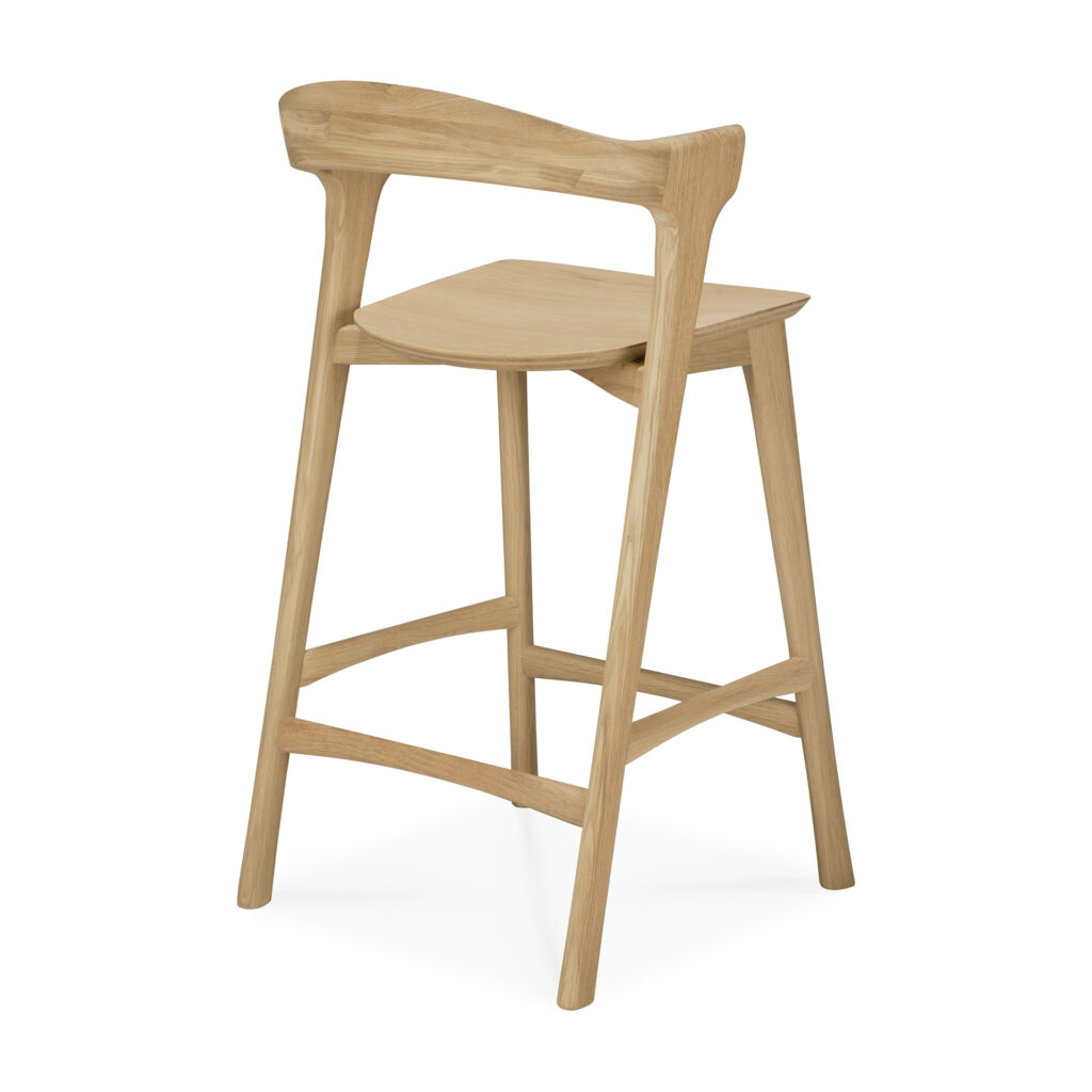 Tabouret de bar en bois clair avec un dossier bas et incurvé, des pieds angulaires et un design Bok minimaliste, positionné sur un fond blanc.