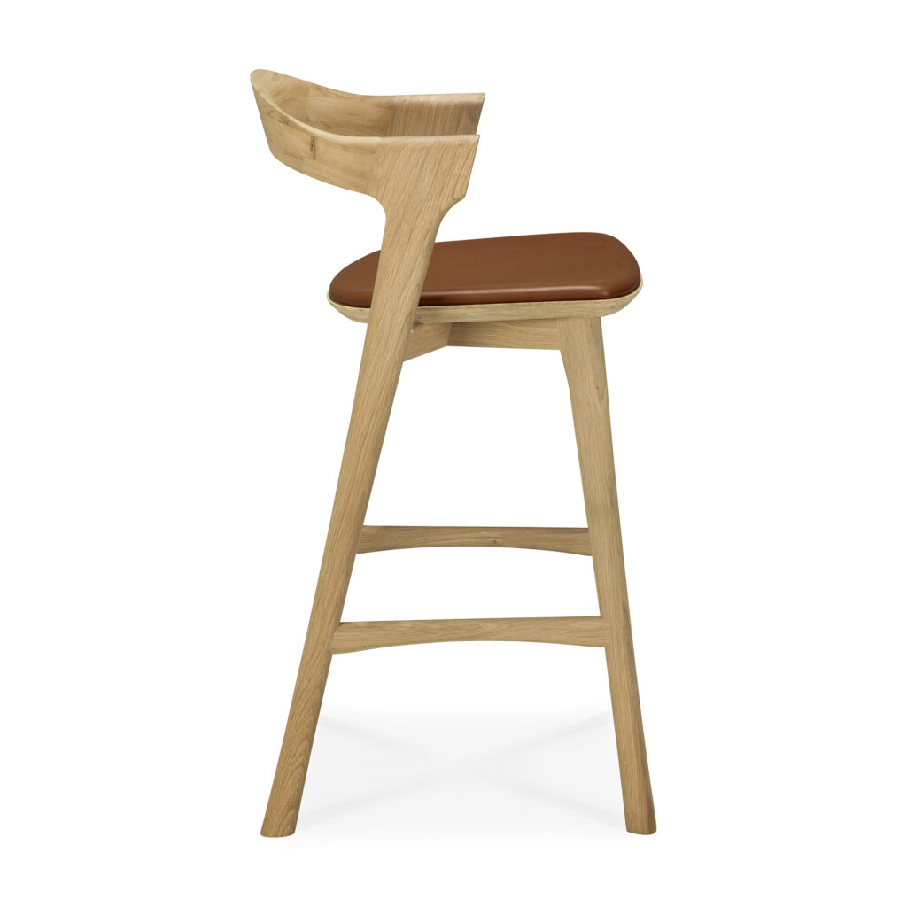Tabouret de bar Bok à dossier incurvé et assise à coussin marron, représenté de profil sur fond blanc.