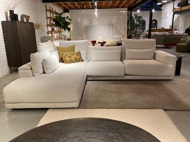 Le canapé sectionnel Olta - Willow (L2Hz+3,5z) C50 3715 Cottage avec des coussins est présenté sur un tapis beige dans la salle d'exposition du salon contemporain sur le thème de Willow Cottage.