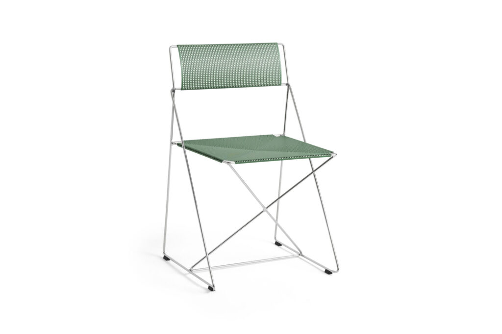 Chaise X-Line verte avec assise et dossier perforés, dotée d'une fine structure métallique, présentée sur un fond blanc craie.