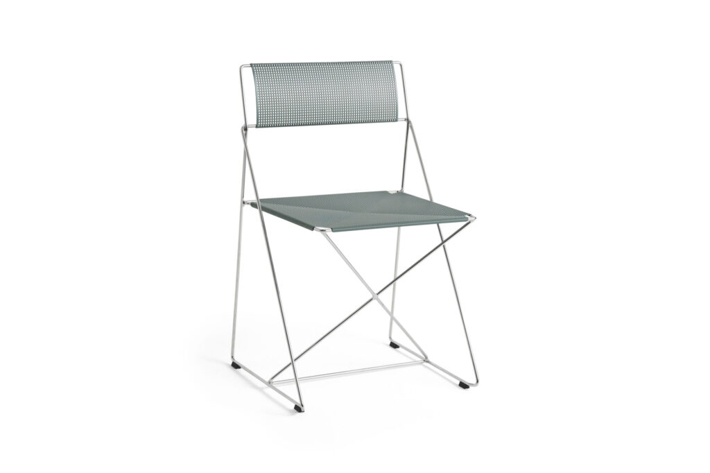 Une chaise X-Line minimaliste avec un dossier perforé et une assise solide et plate en bleu clair, sur un fond blanc uni, alliant un style subtil à une fonction moderne.