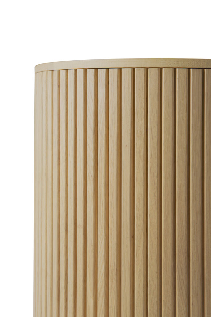 Gros plan sur la table d'appoint ronde Roller Max en Chêne naturel, qui se caractérise par des lattes de bois verticales, un léger veinage visible et un bord incurvé sur le dessus.