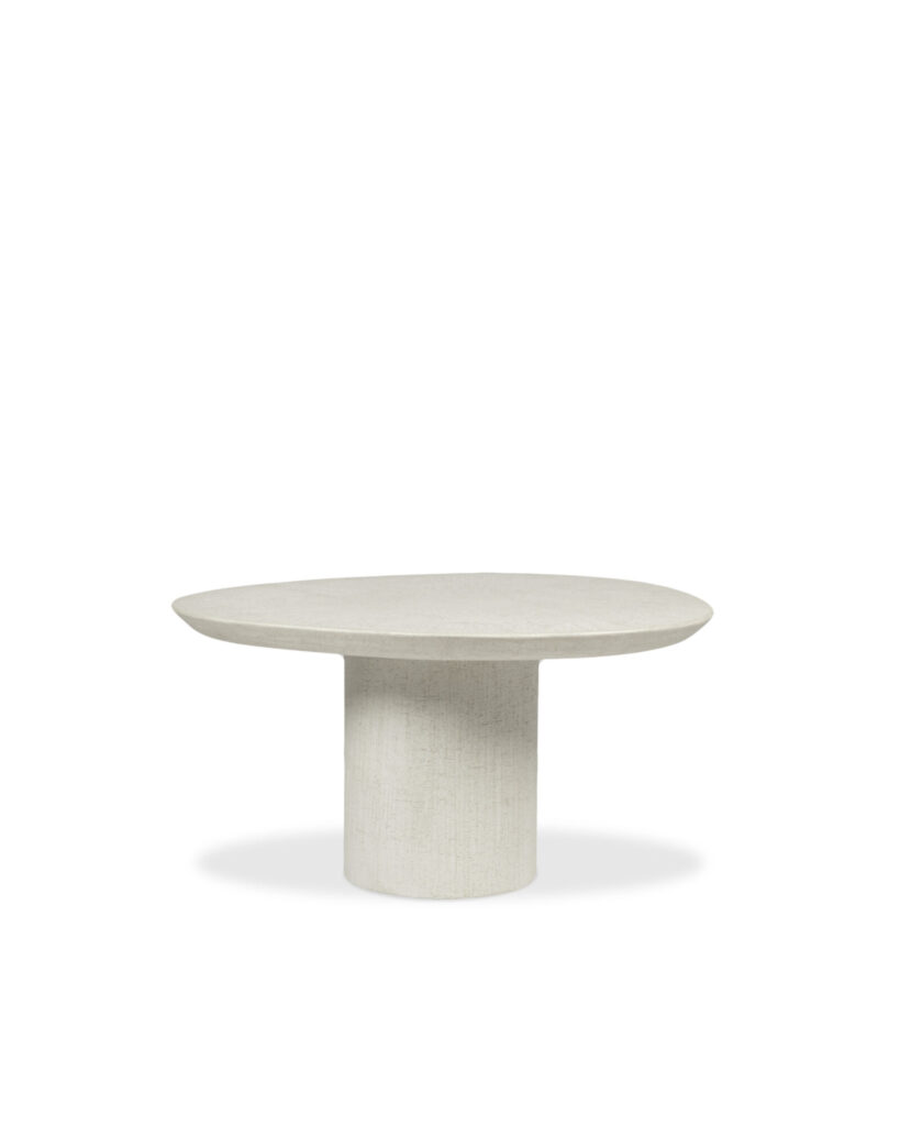 La table basse Ari se compose d'un plateau rond de couleur claire et d'un socle cylindrique épais, sur un fond blanc uni.