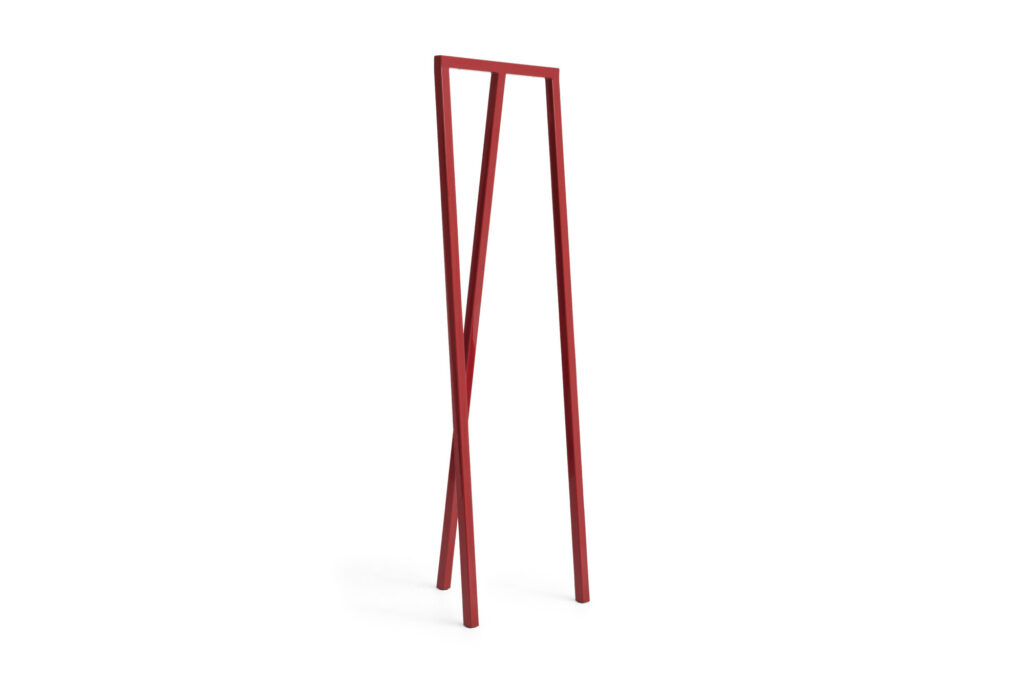 Porte-manteau minimaliste en métal rouge, avec trois pieds angulaires et un simple plateau rectangulaire, sur fond blanc. Une boucle subtile lui confère une élégance moderne.