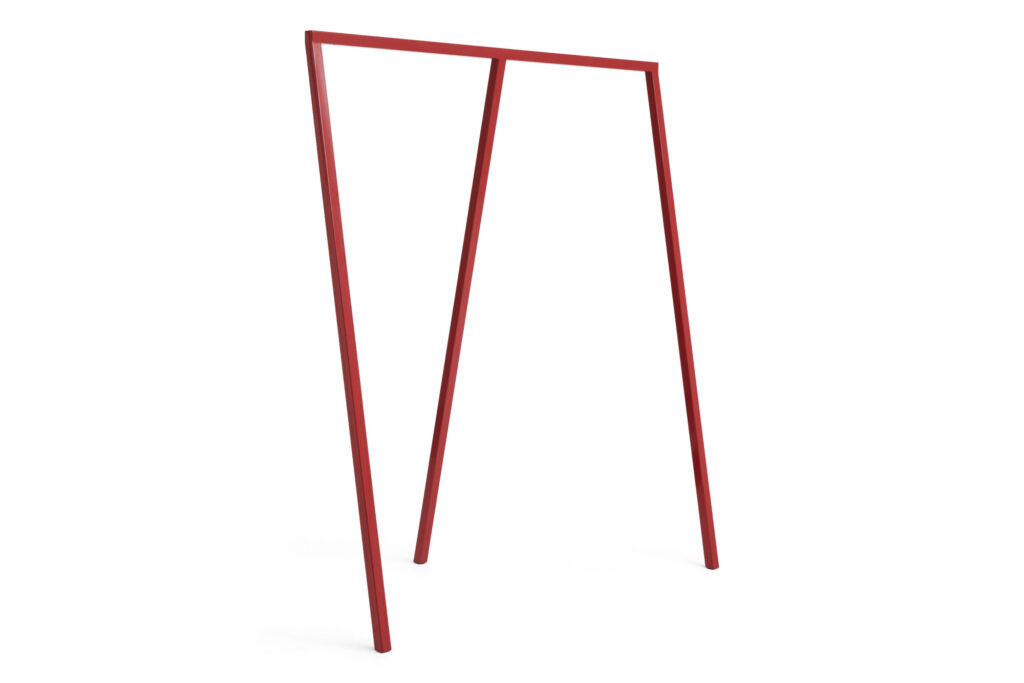 Un cadre métallique Loop minimaliste rouge bordeaux, doté de deux pieds angulaires et d'une barre supérieure horizontale, se tient debout sur un fond blanc - parfait comme porte-manteau moderne.