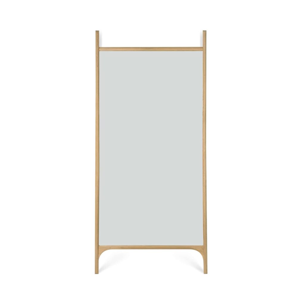 Miroir de sol PI rectangulaire sur toute la longueur, avec un cadre en bois clair, reposant verticalement sur deux pieds.