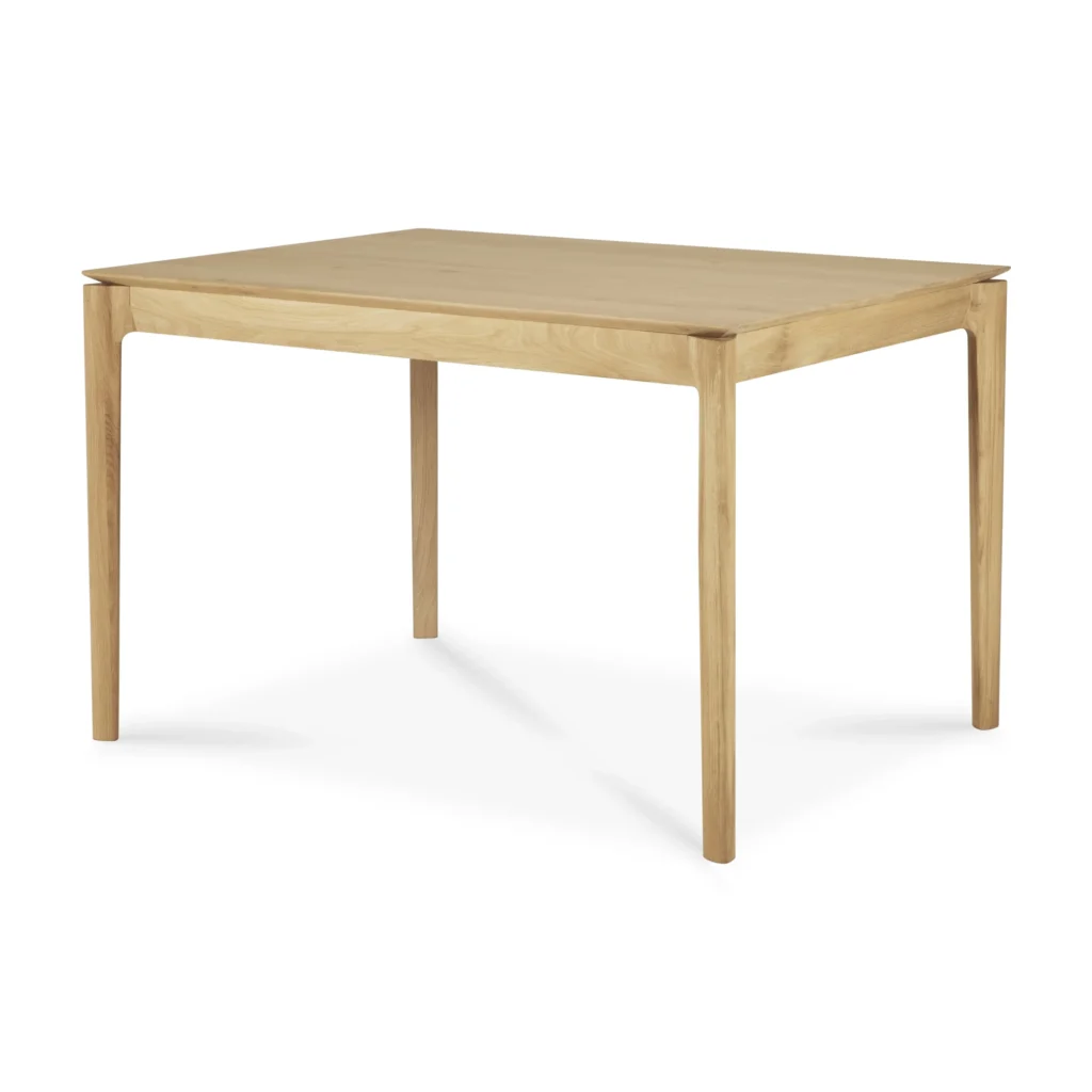 Table de salle à manger rectangulaire en bois à rallonge avec quatre pieds droits, finie dans un chêne naturel verni, sur un fond blanc uni.