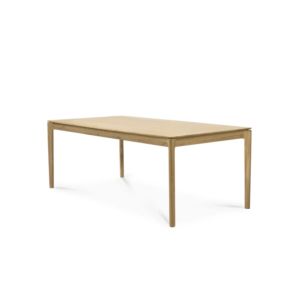 Cette table à rallonge rectangulaire en bois chêne naturel avec quatre pieds droits, sur un fond blanc uni, offre un style polyvalent pour tout espace moderne.
