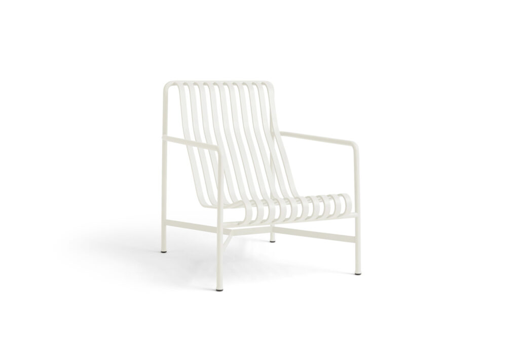 Le Fauteuil bas Palissade, de couleur blanc crème, est une chaise de salon en métal blanc au design minimaliste et au cadre ouvert, avec une assise et un dossier à lattes, photographiée sur un fond blanc uni.