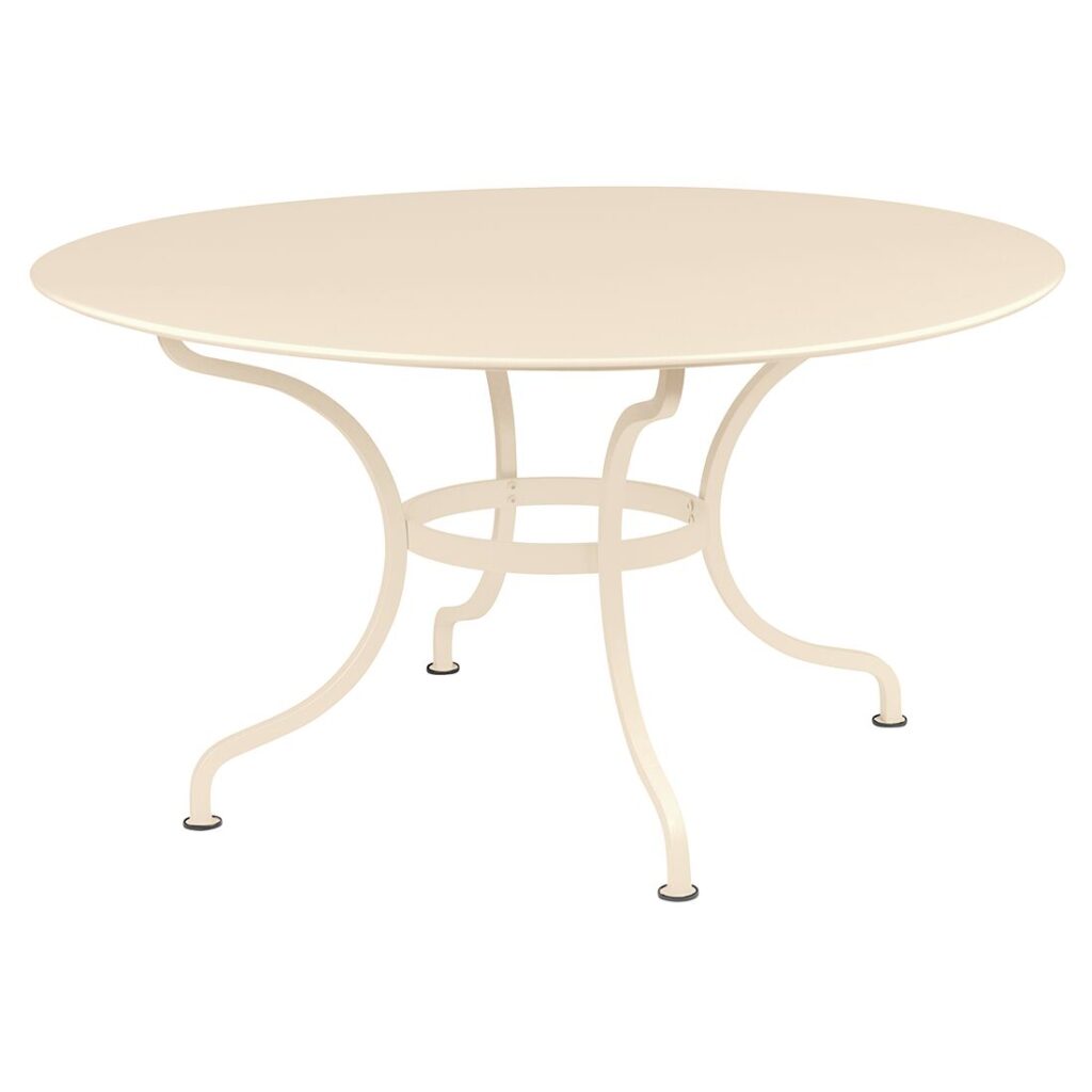 Table ronde en métal latté beige avec pieds courbés, présentée sur fond blanc. La Table ronde Romane mesure 140 cm de diamètre.