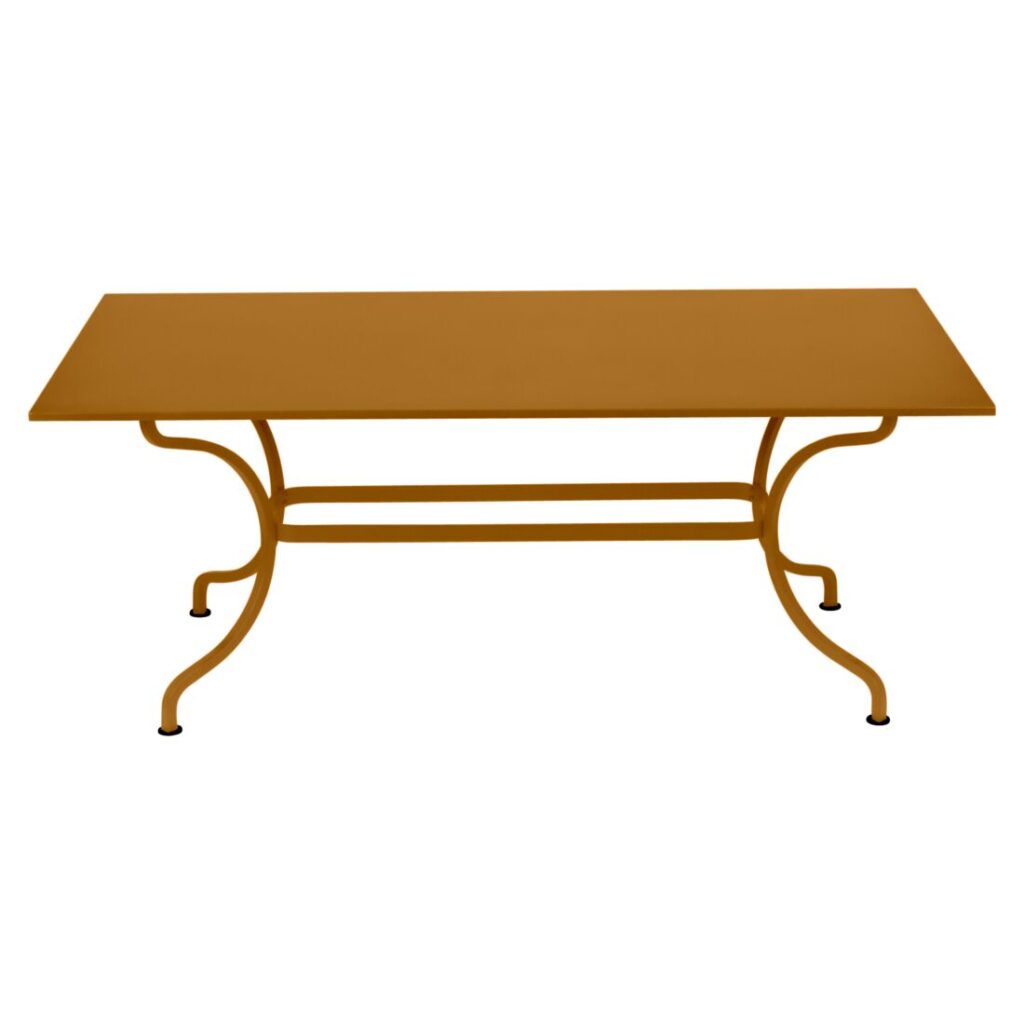 Table Romane rectangulaire jaune moutarde avec des pieds incurvés et une barre de soutien horizontale, rappelant la teinte Pain d'épices, présentée sur un fond blanc.